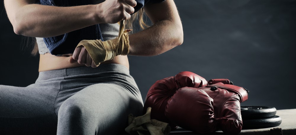 Mulher treinando crosstraining com pesos em academia